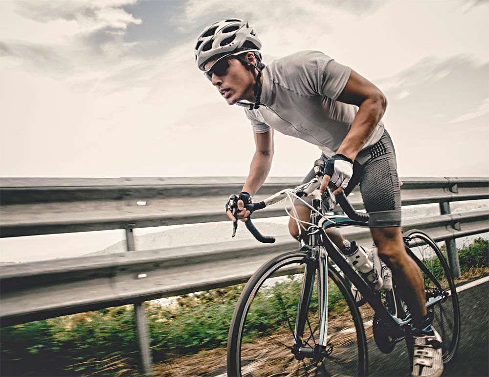 Cycliste dans un effort maximum sur route pour améliorer