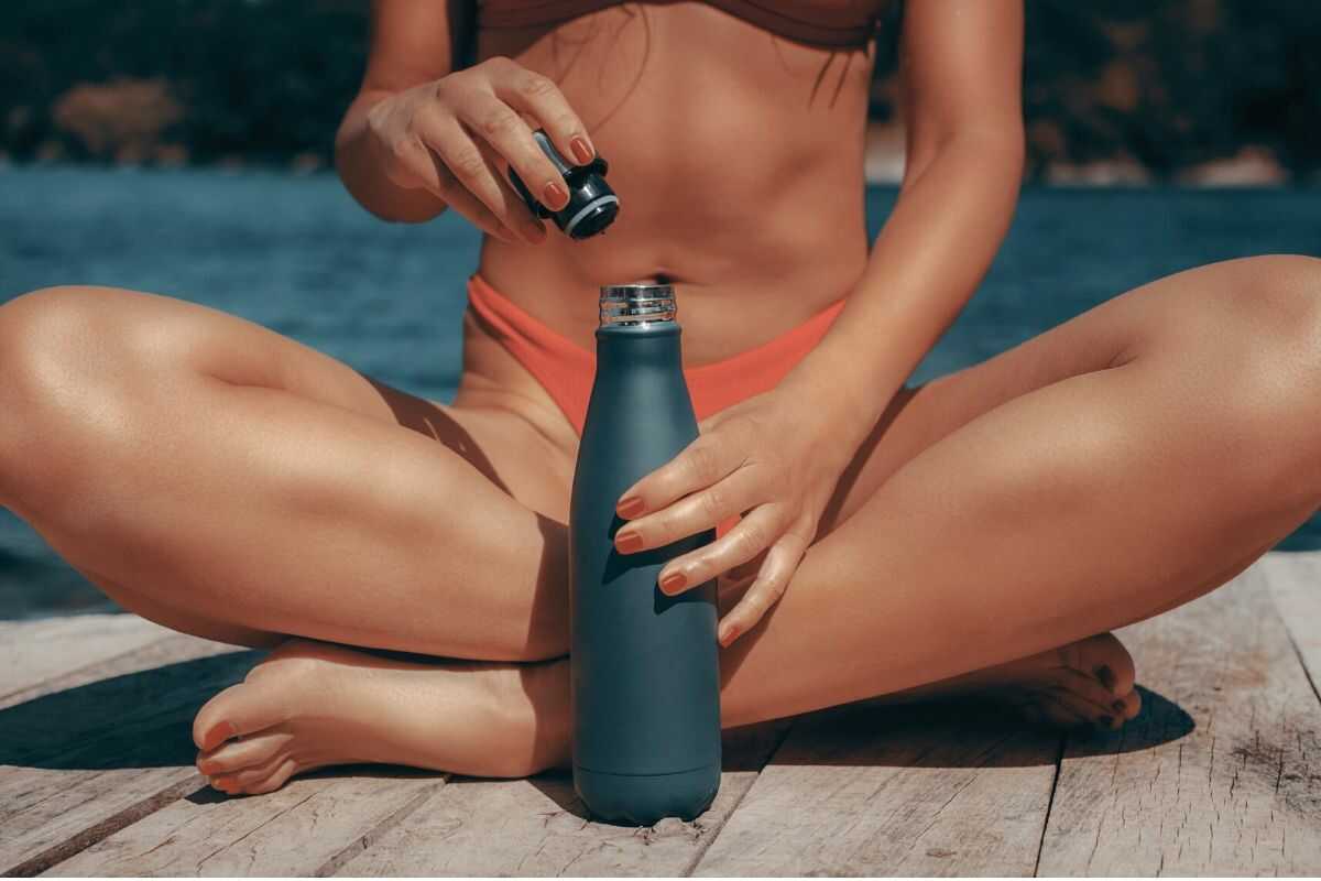 ragazza in bikini con bottiglia riutilizzabile ragazza in bikini con bottiglia riutilizzabile